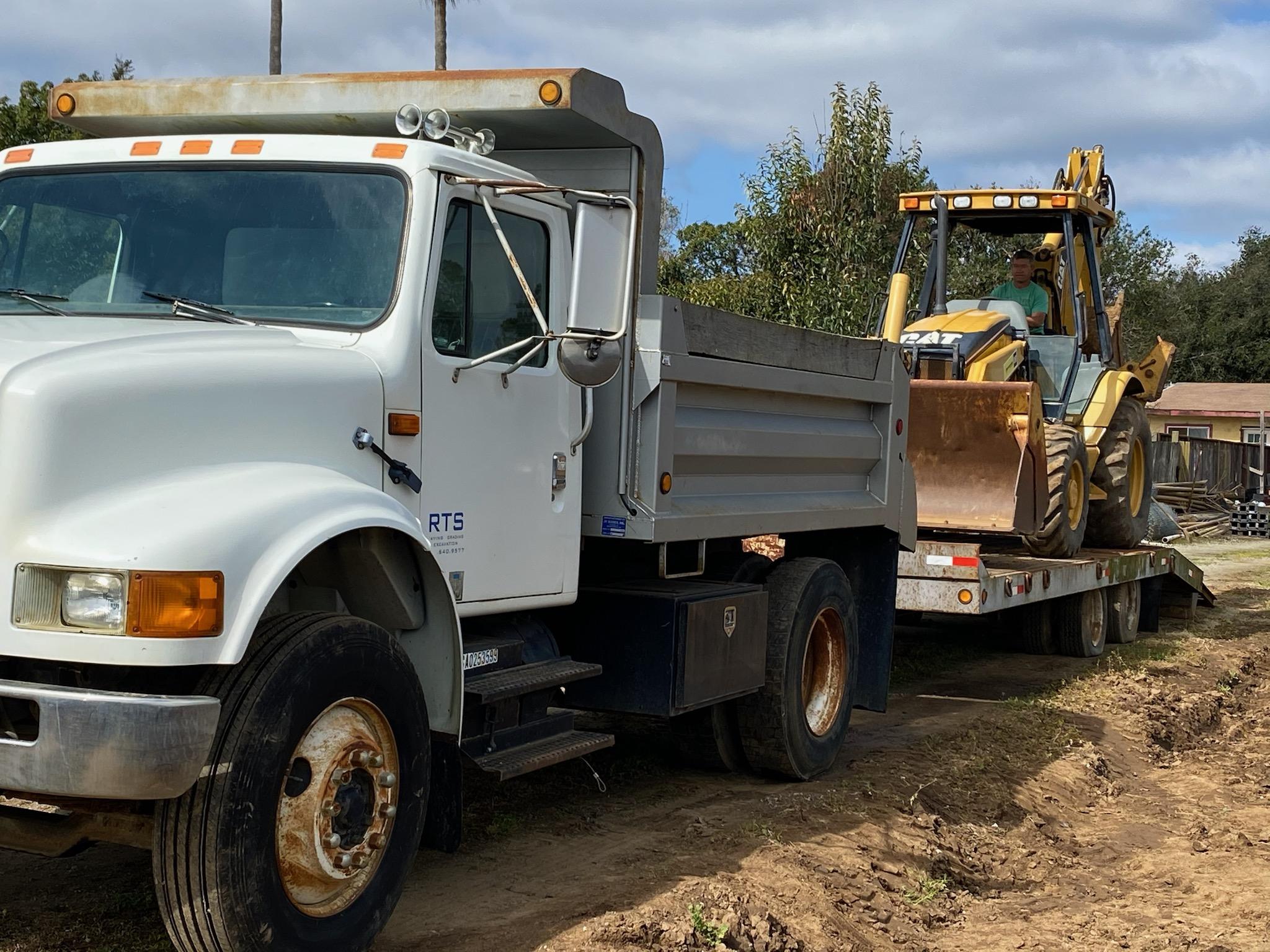 Dump Truck with Backhoe on trailer behind Dump Truck with Backhoe on trailer behind