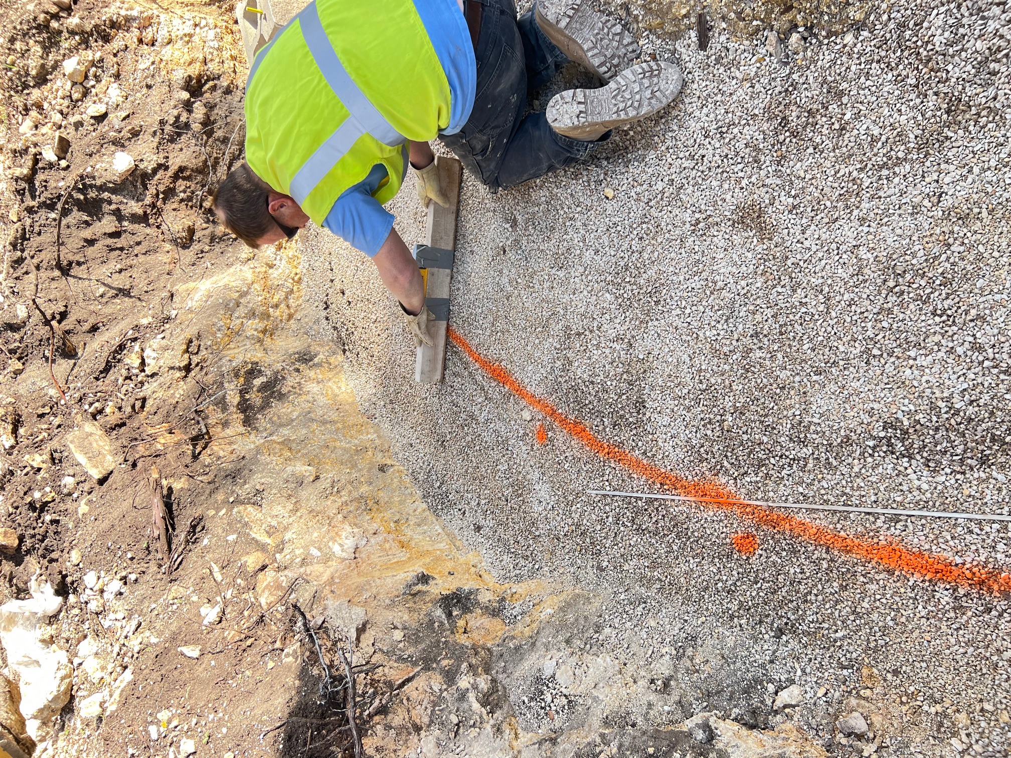 worker performing the layout for a block retaining wall